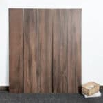 Scandinavian Espresso Brown Wood Look Tile planks displayed, showcasing their rich hardwood look and authentic texture. This 100% waterproof porcelain tile offers unmatched resilience and effortless care for timeless elegance.