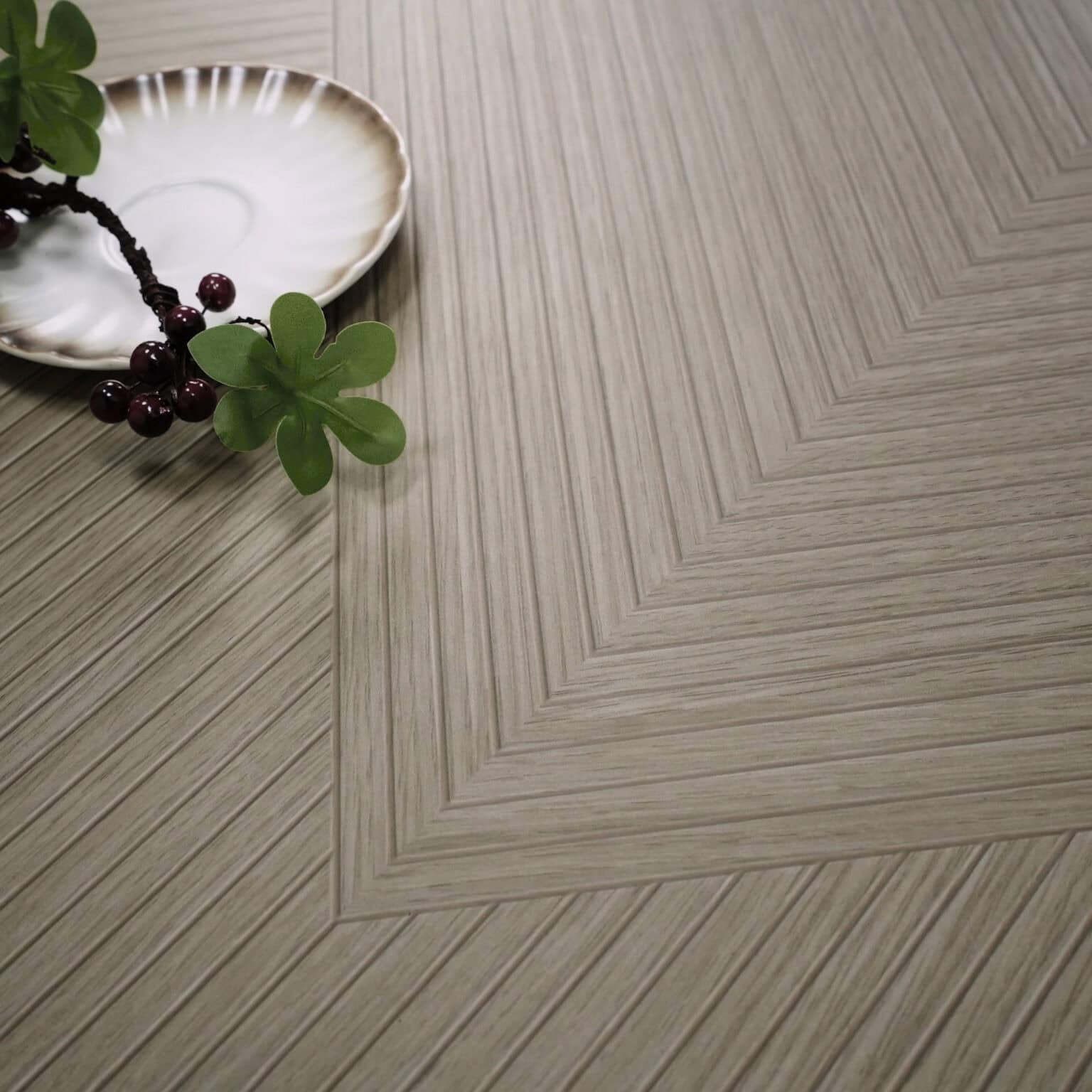 Close-up of Modern Minimalist Warm Grey Wood Look Tile on a living room floor, highlighting its intricate pattern and soft, warm grey tones. This 100% waterproof porcelain tile offers unmatched durability, resisting scratches and stains for a worry-free, modern design.