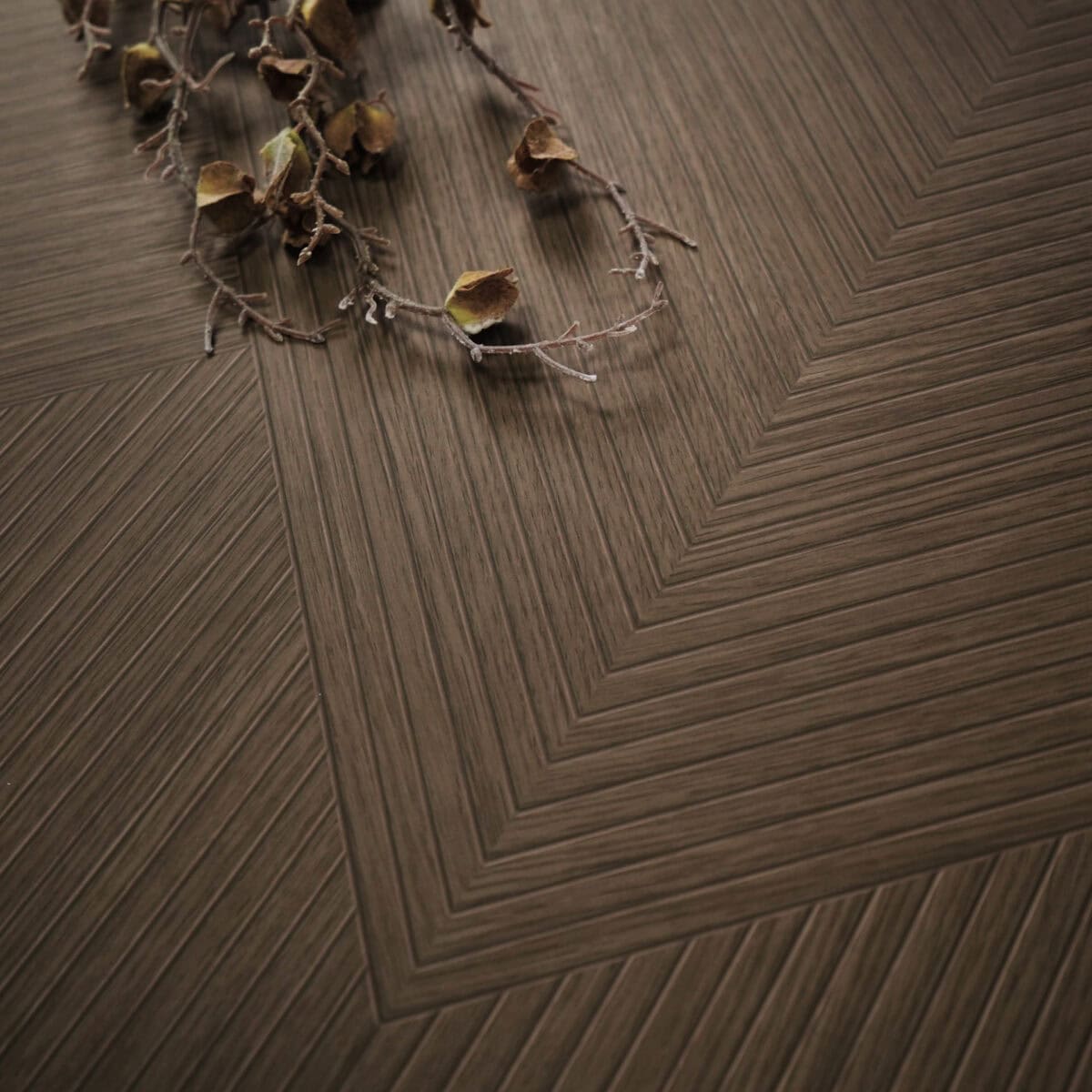 Close-up of Art Deco Cocoa Brown Wood Look Tile on a living room floor, highlighting its intricate pattern and rich cocoa-brown tones. This 100% waterproof porcelain tile offers unmatched durability, resisting scratches and stains for a worry-free, elegant design.