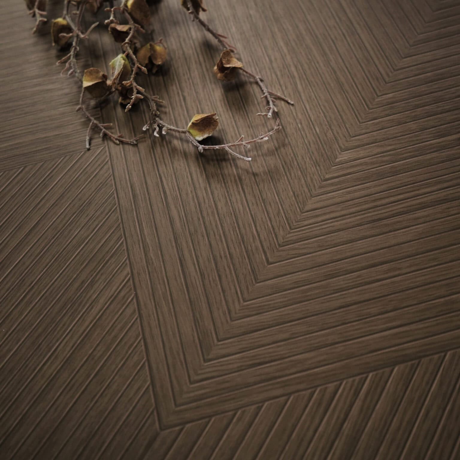 Close-up of Art Deco Cocoa Brown Wood Look Tile on a living room floor, highlighting its intricate pattern and rich cocoa-brown tones. This 100% waterproof porcelain tile offers unmatched durability, resisting scratches and stains for a worry-free, elegant design.