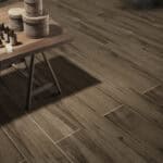 Industrial Smoked Brown Wood Look Tile on a kitchen floor, creating a powerful, sophisticated industrial atmosphere. This 100% waterproof porcelain tile offers unmatched durability, resisting scratches and stains for a worry-free lifestyle.