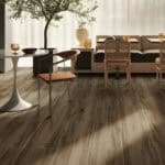 Industrial Smoked Brown Wood Look Tile on a living room floor, enhancing a bold, sophisticated industrial chic design. This 100% waterproof porcelain tile offers unmatched durability, resisting scratches and stains for a worry-free lifestyle.