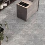 Serene Sanctuary Athens Gray Stock Look Vinyl Flooring in a modern kitchen, evoking timeless marble elegance with soft gray tones. This 100% waterproof vinyl resists scratches, stains, and dents, offering an effortless to clean, low-maintenance foundation for a tranquil and elegant home.