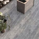 Urban Chic Pietra Gray Stone Look Vinyl Flooring in a modern kitchen, creating a serene, minimalist calm. This durable vinyl is 100% waterproof, highly resistant to scratches, stains, and dents, making it ideal for busy kitchen environments and effortless to clean for a sophisticated life.