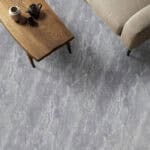 Urban Chic Pietra Gray Stone Look Vinyl Flooring in a minimalist living room, establishing a serene, grounded feel. This sophisticated vinyl is 100% waterproof, highly resistant to scratches, stains, and dents, offering a low-maintenance style for a modern, uncluttered life.
