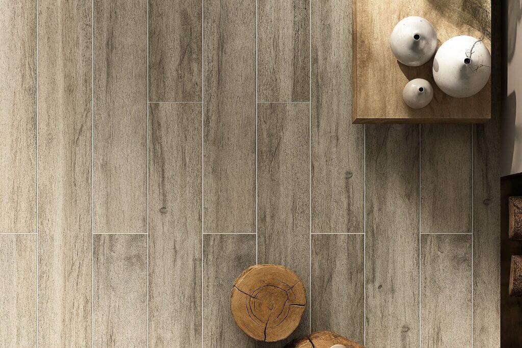 Top-down view of a warm-toned wood-look porcelain tile design featuring realistic grain texture and staggered plank layout, styled with ceramic vases and natural wood decor accent