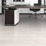 Professional Modern Whitewash Oak SPC flooring in a high-end office with a dark executive desk.