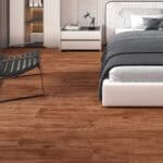 Amazing Contemporary Warm Teak SPC flooring in a modern bedroom with a black leather chair and white furniture.