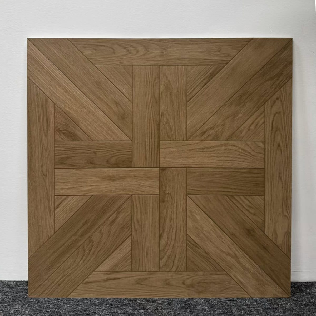 Real photo of a single French Style Umber Tone Walnut Wood Look Tile, showcasing its intricate parquet pattern and warm wood grain.