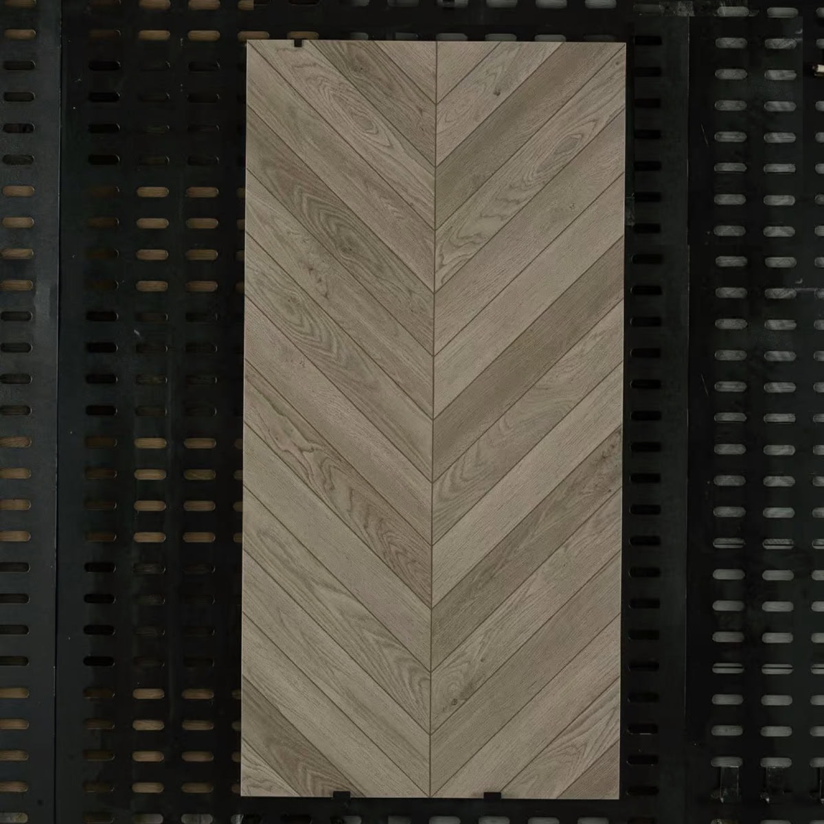 Real photo of a single Minimalist Luxury Wood Color Wood Look Tile, showcasing its elegant chevron pattern and natural oak wood grain.