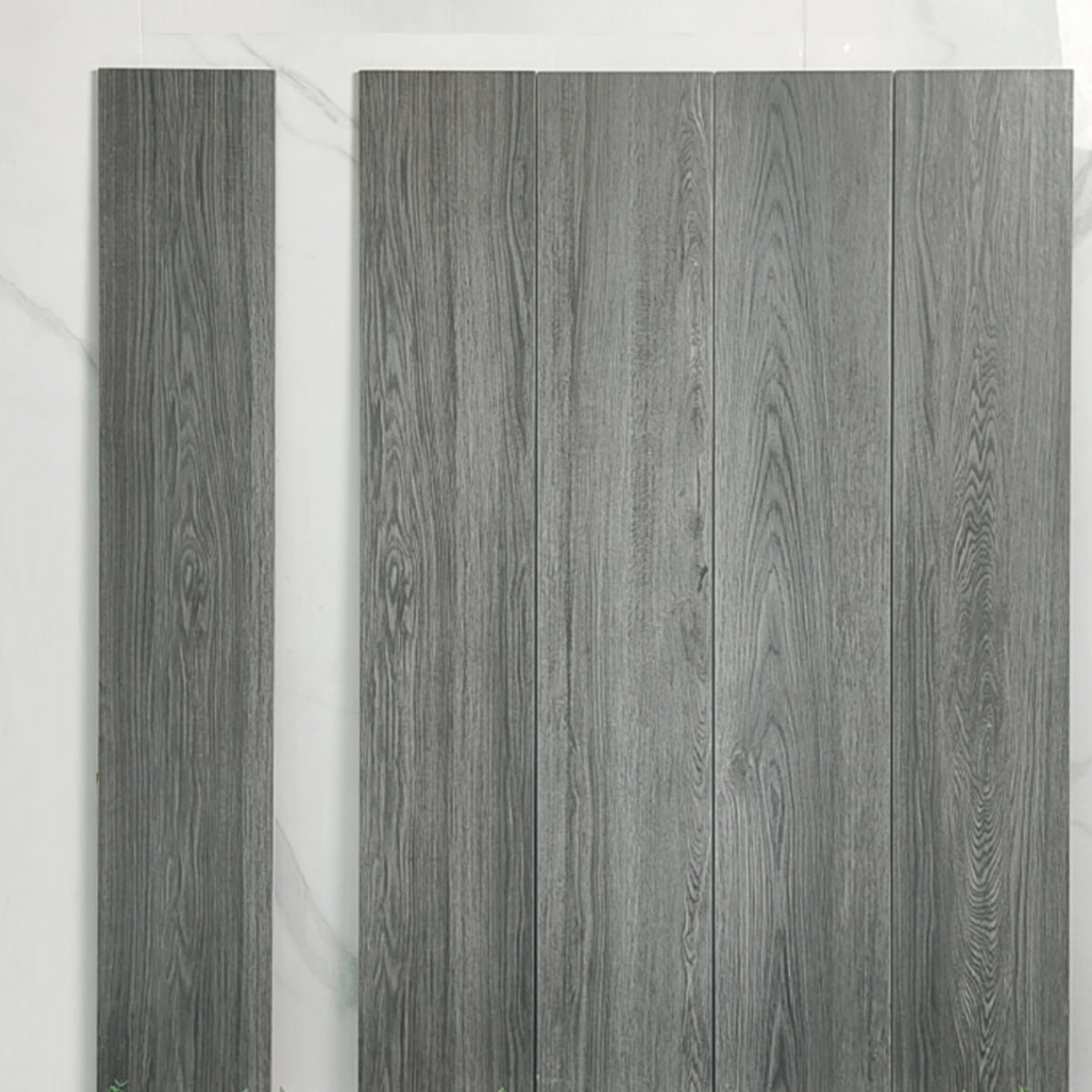 Real photo of Modern Minimalist Charcoal Gray Wood Look Tile planks, showing their deep gray tones and detailed wood grain texture.
