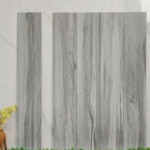 Real photo of Scandinavian Light Gray Oak Wood Look Tile planks, showing their minimalist wood grain and bright, cool-toned color.