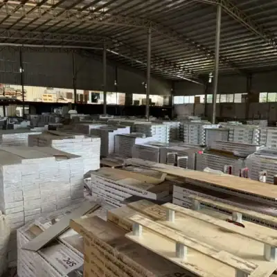 Wide aisle view of vividcozytile Foshan warehouse, stacked pallets of SPC vinyl plank flooring on blue pallets.