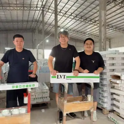 vividcozytile production team in Foshan holding LVT flooring packaging during in-warehouse quality inspection.